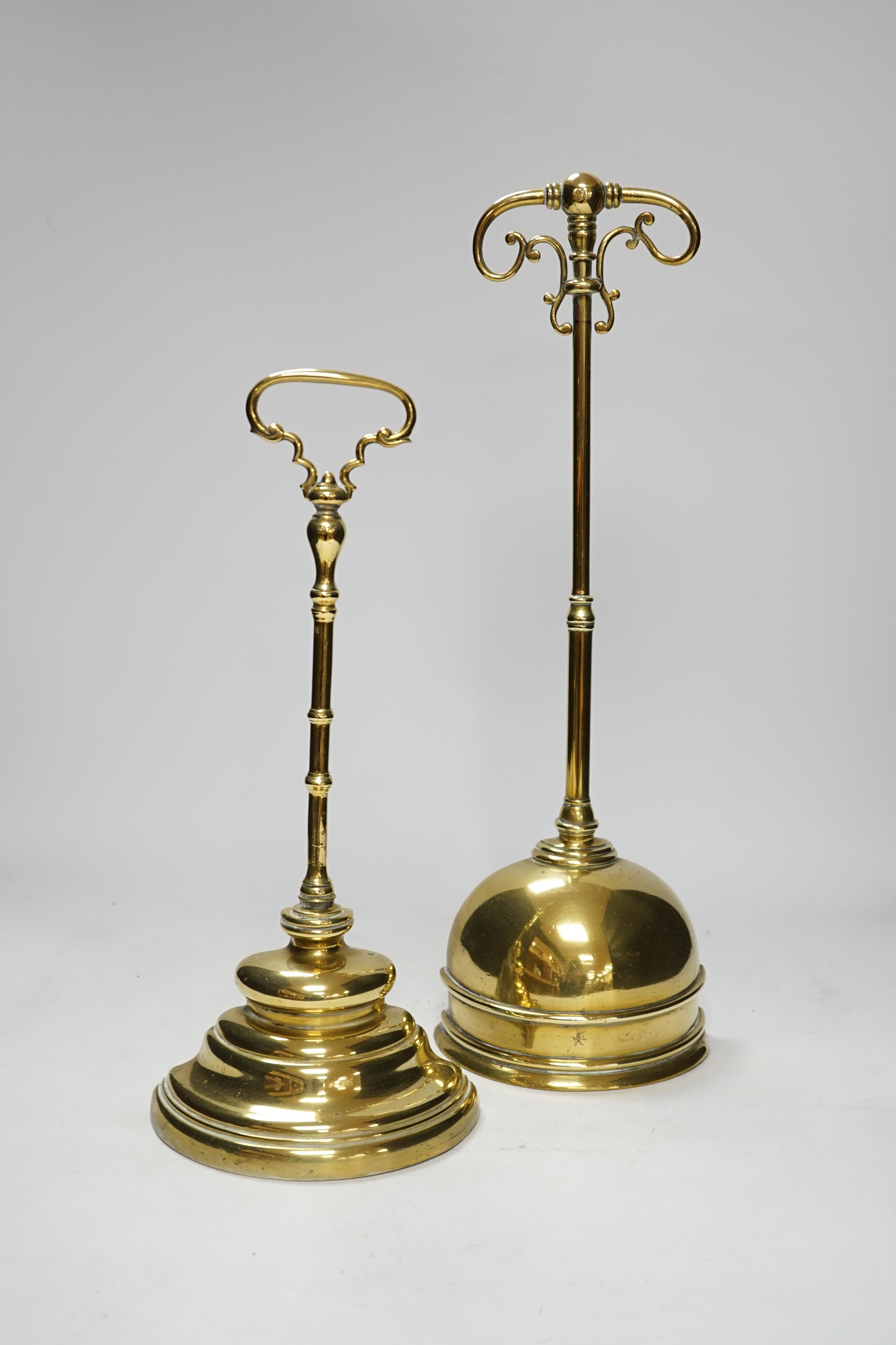 Two early 19th century cast brass door stops, with moulded stepped plinths, largest 45cm high